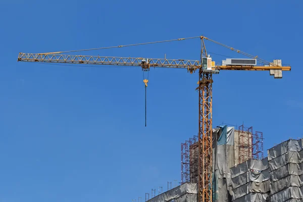 Žlutá stavební jeřáb pozadí modré oblohy — Stock fotografie