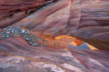 Durgun su havuzuyla dolu bir kanyonun manzarası ve kaya çıkıntılarının yansımaları, Ateş Eyaleti Vadisi Parkı, Nevada, ABD