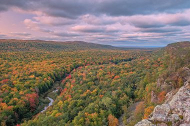 Bond Şelalesi 'ndeki bir çağlayanın manzarası hareket bulanıklığı ile çekildi ve güneşli sonbahar akçaağaçlarının ve mavi gökyüzünün yansımasıyla aydınlandı. Michigan' ın Yukarı Yarımadası, ABD