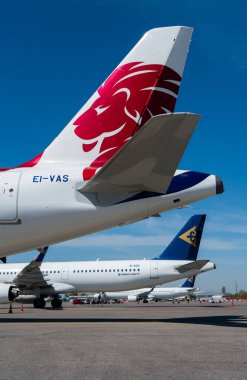 Güneşli bir günde halka açık havaalanında çeşitli nakliye uçakları