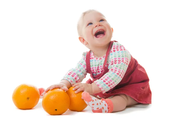 Bebê e três laranjas — Fotografia de Stock