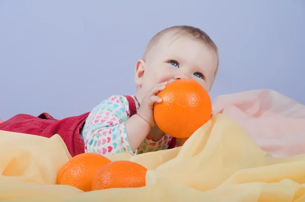 Baby met sinaasappelen — Stockfoto