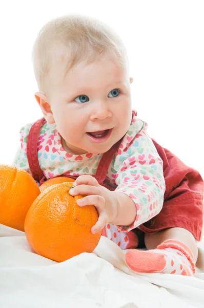 Baby met sinaasappelen — Stockfoto
