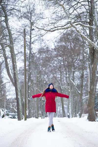 Jonge vrouw in rood genieten van de winter buiten — Stockfoto