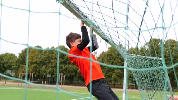 Tiener jongen stopt op voetbal poorten — Stockvideo