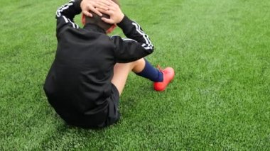 Genç çocuk futbol antrenmanından önce ısınmak için mekik çekiyor.