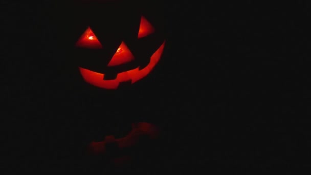 Halloween gloeiende pompoen op zwarte achtergrond — Stockvideo