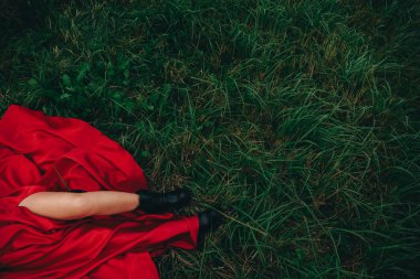 Yeşil çimlerin üzerinde siyah çizmeli kadın bacakları