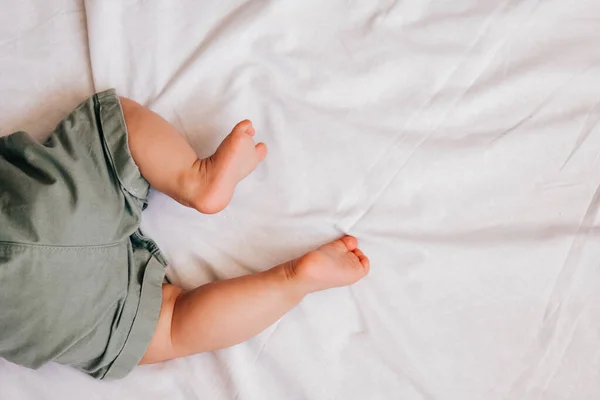 Cute 6 month baby feet on white sheet — Stock Photo, Image