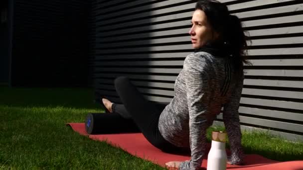 Mujer en forma joven haciendo ejercicio trasero usando rodillo de espuma en el gimnasio — Vídeos de Stock