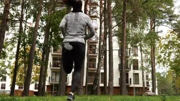 Young woman exercising doing butt kicks outdoors — 비디오