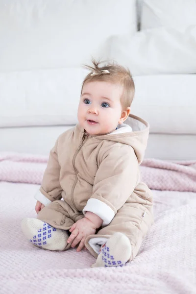 Adorable baby in warm overall sitting on the blanket — Stockfoto