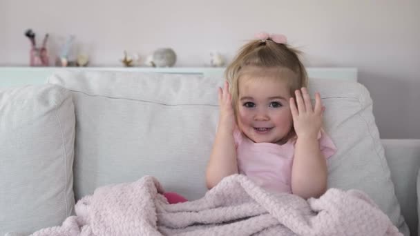 En söt liten flicka som täcker ögonen med händer och leker kurragömma — Stockvideo