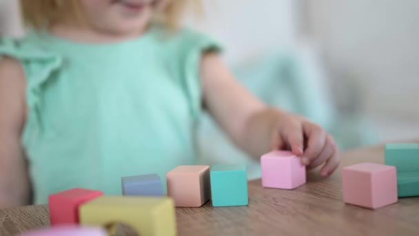 Felismerhetetlen kislány játszik színes fa kockák — Stock videók