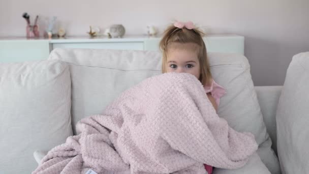 Schattig klein meisje verstopt zich achter de deken — Stockvideo