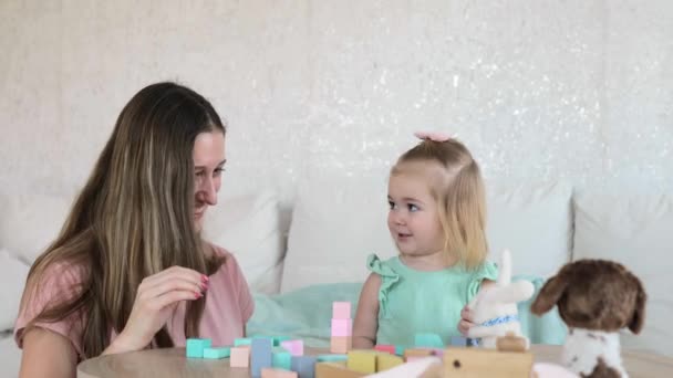 사랑 스러운 어린 소녀가 어머니와 함께 형형색색 의나무 큐브를 가지고 노는 모습 — 비디오