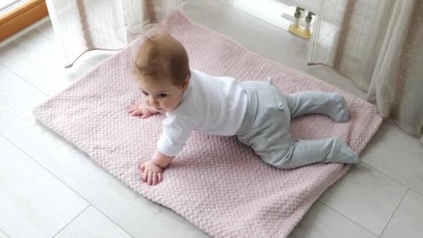 Adorable bebé de 6 meses acostado en el estómago sobre una manta — Vídeos de Stock