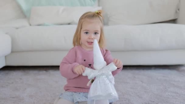 Adorable niña jugando con muñeca blanca — Vídeo de stock