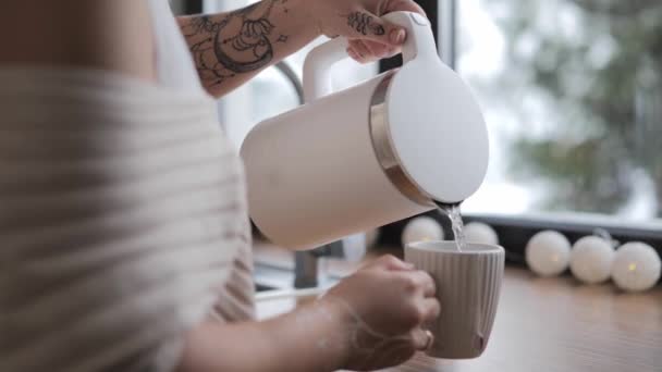 Mulher mão derrama chá quente de chaleira em copo em casa — Vídeo de Stock