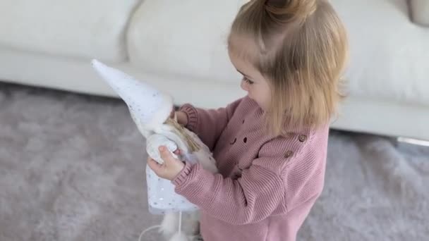 Schattig klein meisje spelen met witte pop — Stockvideo
