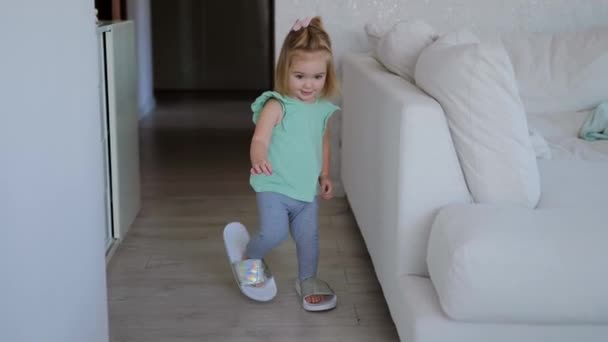 Spädbarn flicka bär mödrar skor. — Stockvideo