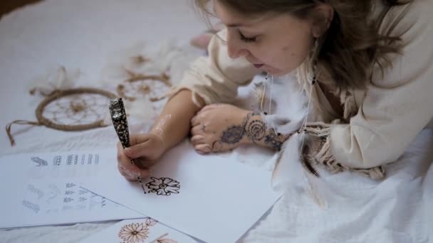Fiatal nő gyakorolja henna vagy mehndi tervez papíron