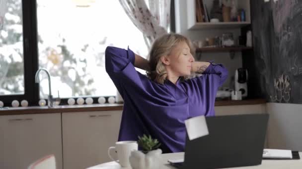 Жінка працює вдома в офісі, друкуючи ноутбук, а потім робить вправи для розтягування — стокове відео
