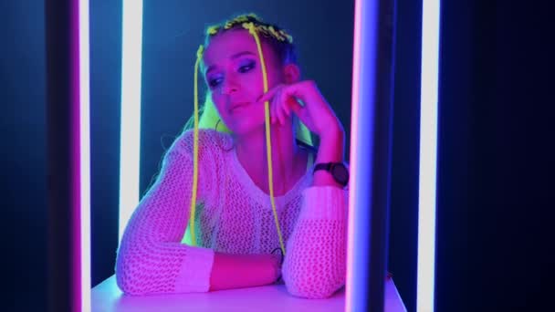 Millennial ung kvinna med gult hår i trendiga neon rosa och blått ljus. — Stockvideo