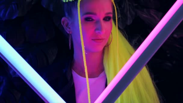Millennial młoda kobieta z żółtymi włosami w modnym neon różowe i niebieskie światła. — Wideo stockowe