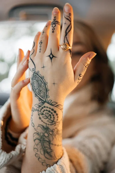 Unrecognisable young lady with painted hand sacral mehendi. Winter mood