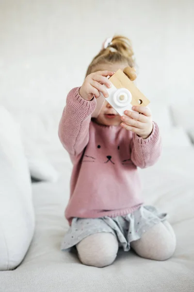 Small Adorable Girl Holding Wooden Toy Photo Camera Hiding Face — Stockfoto