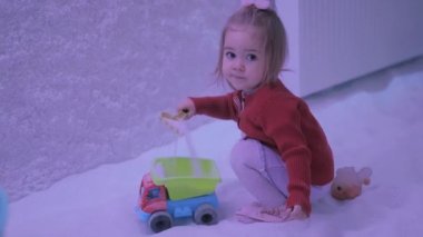 Küçük kız tuz odasında kürek kemiği ve kamyonla oynuyor. Çocuklar için haloterapi 