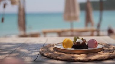 Plaj kafesinde, güzel deniz manzaralı ahşap masada servis edilen üç çeşit badem kurabiyesi. Tatilde nefis yemekler.