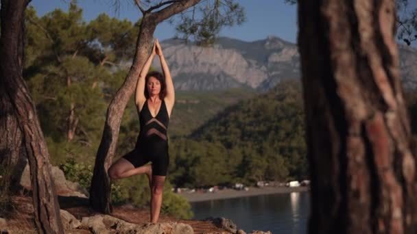 Young Woman Practicing Vrikshasana Tree Yoga Pose Outdoors Hill Sea — Vídeo de Stock