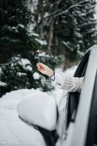 Woman Hand Holding Sparklers Car Window Winter Travel Weekend Recreation — Stock Photo, Image
