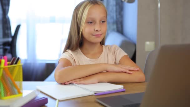 Online oktatás. iskoláslány válaszol a tanárok kérdésére online egy laptopon. — Stock videók
