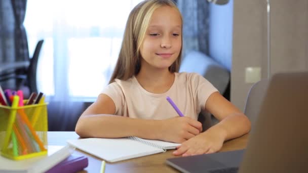 Colegiala estudia en línea utilizando un ordenador portátil moderno. Tareas — Vídeos de Stock