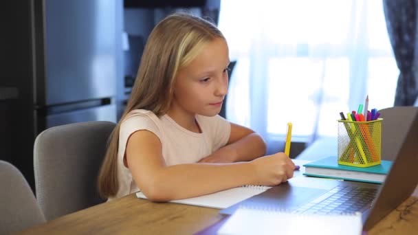 Iskoláslány tanulmányok online egy modern laptop. Házi feladat — Stock videók