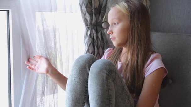 Dziewczyna w złym nastroju jest sama w domu przy oknie. — Wideo stockowe