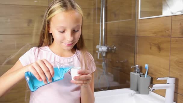 Girl uses mouthwash in the bathroom close-up — Stock Video