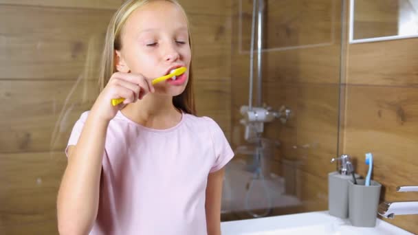 A girl brushes her teeth in the bathroom close-up. Oral care — Stock Video