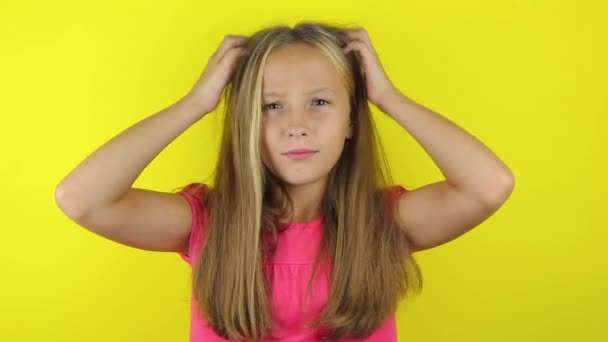 Девушка чешет голову на цветном фоне — стоковое видео