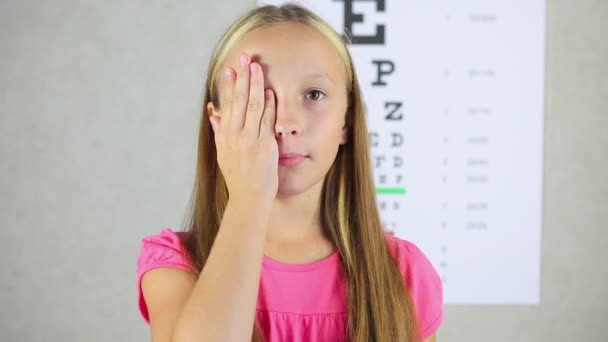 Dziewczyna w dobrym nastroju sprawdza wzrok u okulisty. — Wideo stockowe