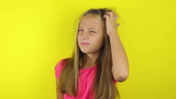 Девушка чешет голову на цветном фоне — стоковое видео