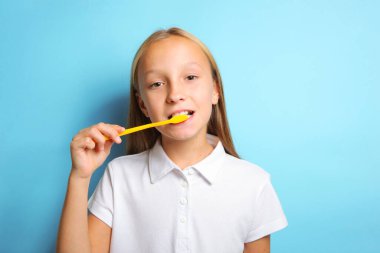 Keyfi yerinde bir kız dişlerini fırçalıyor.