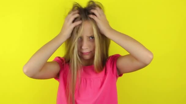 Κορίτσι γρατσουνιές το κεφάλι της σε ένα έγχρωμο φόντο — Αρχείο Βίντεο