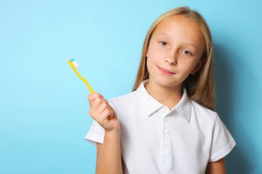 Keyfi yerinde bir kız dişlerini fırçalıyor.