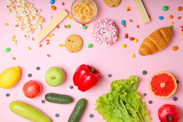 Gesunde Lebensmittel und ungesunde Lebensmittel auf farbigem Hintergrund Nahaufnahme von oben. — Stockfoto