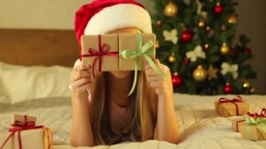 Noel için dekore edilmiş bir evde çocuk bayram hediyelerini açıyor. 