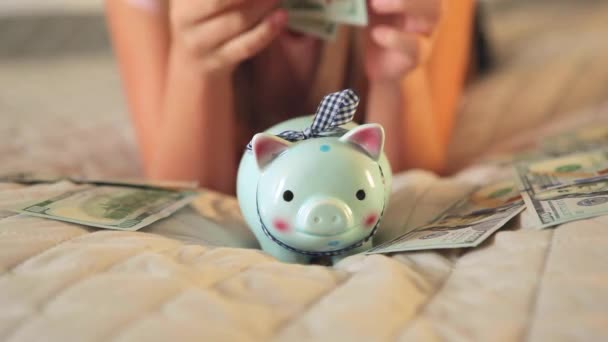 Genç kız evdeki kumbaralara para yatırıyor. — Stok video